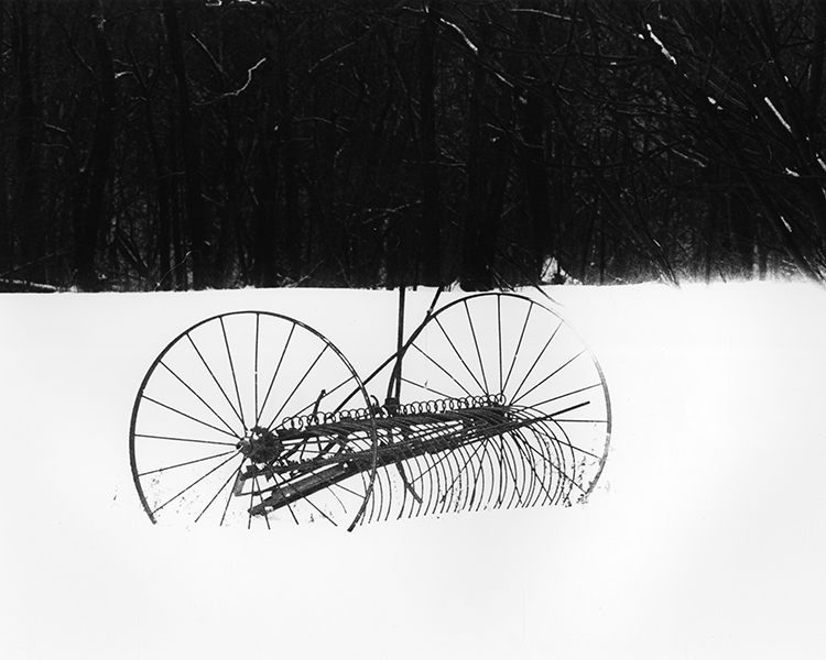 old-fashioned metal hay rake in a field, 1981, by William Wynne